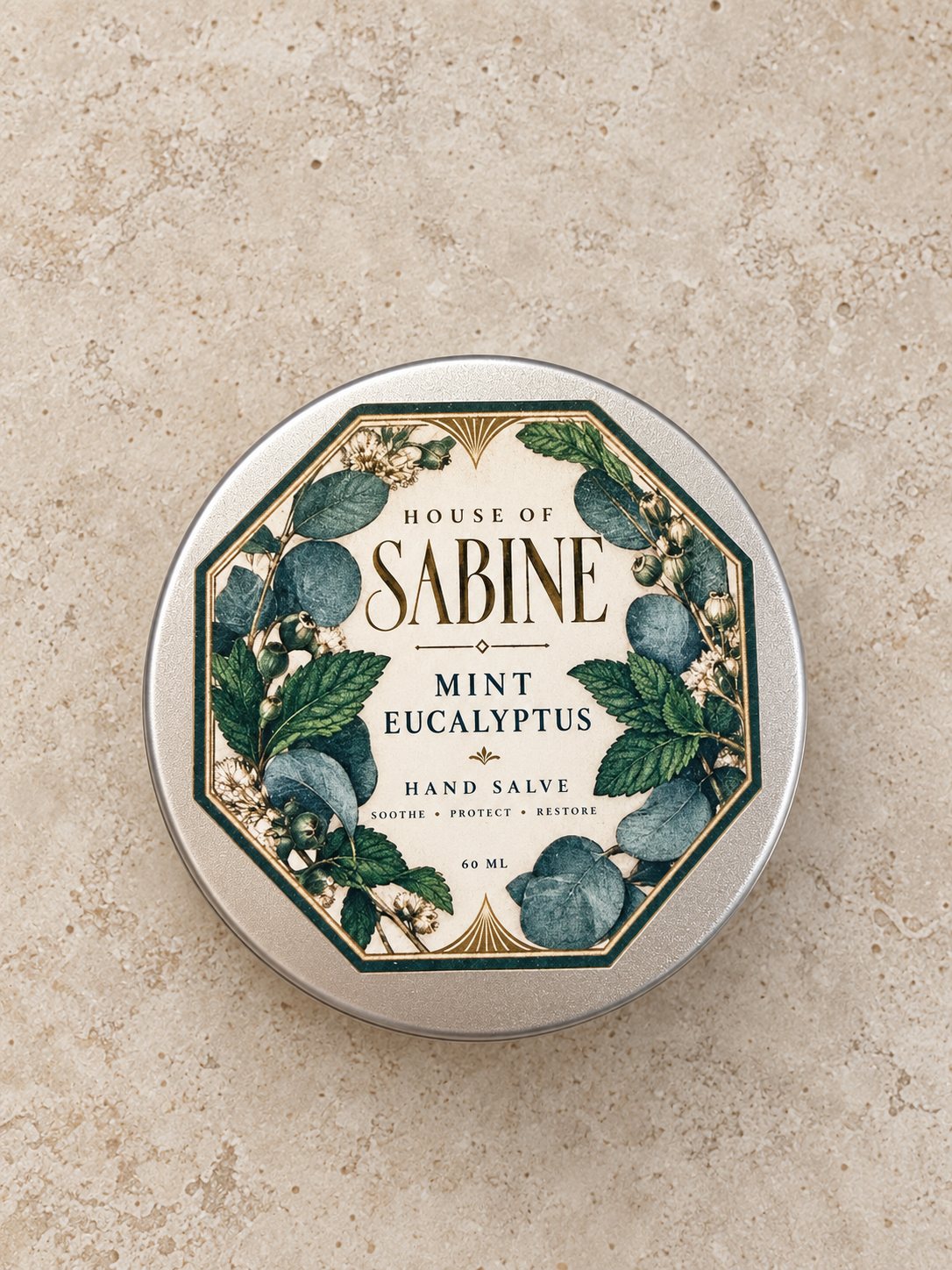 Round silver tin of Mint Eucalyptus hand salve with an octagonal botanical label of mint and eucalyptus leaves